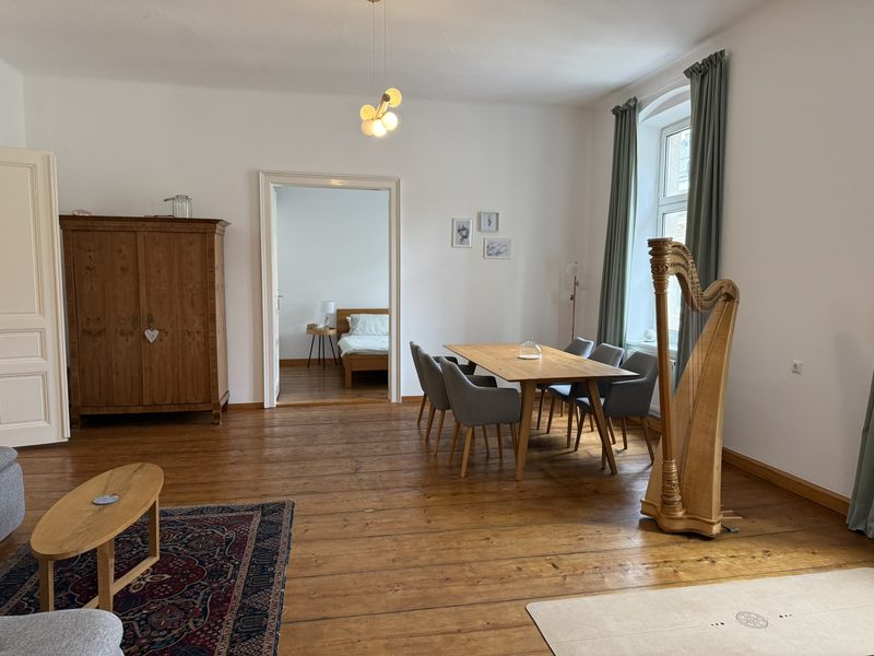 Altbauzimmer mit Dielenboden, Kastenfenster, Stucktür und historischem Holzschrank